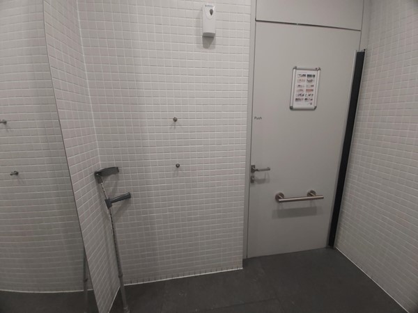 Image of a bathroom with a door and a broom