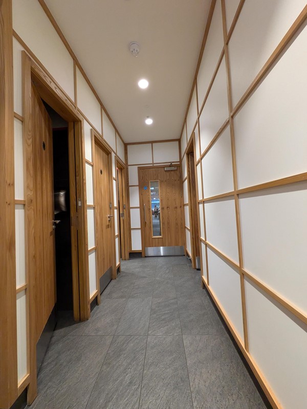 Image of a hallway with wood panelled walls and a door