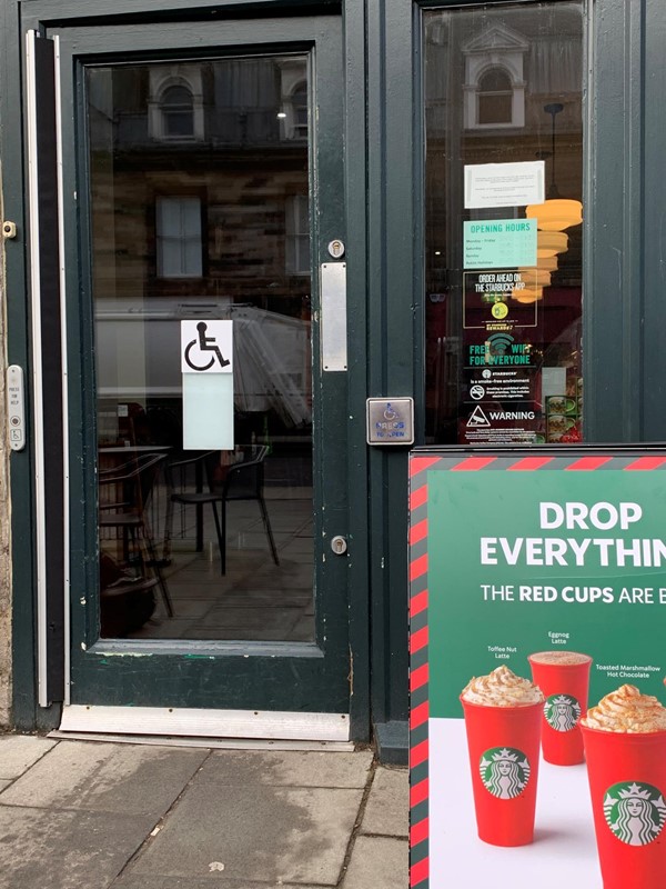 Image of shop going in, wheelchair symbol on door and push pad on right hand side