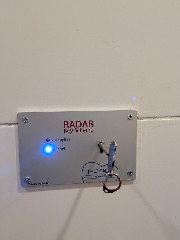 Image of the RADAR key lock, a metal panel on the wall with a key hole