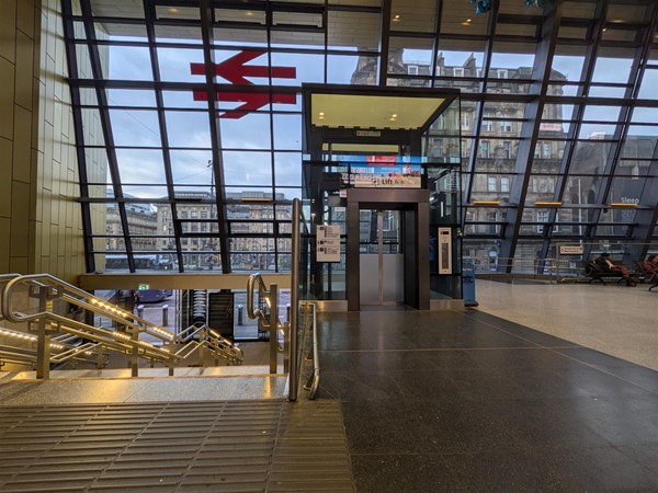 Image of lift access and stairs with tactile markings and grab rails