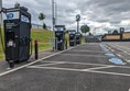 Image of row of electric charging stations in a parking lot, ready to power up electric vehicles
