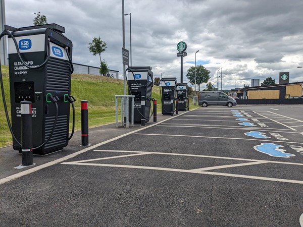 Image of row of electric charging stations in a parking lot, ready to power up electric vehicles