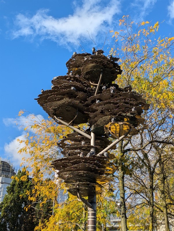 Image of a tree-like sculpture with nesting pigeons