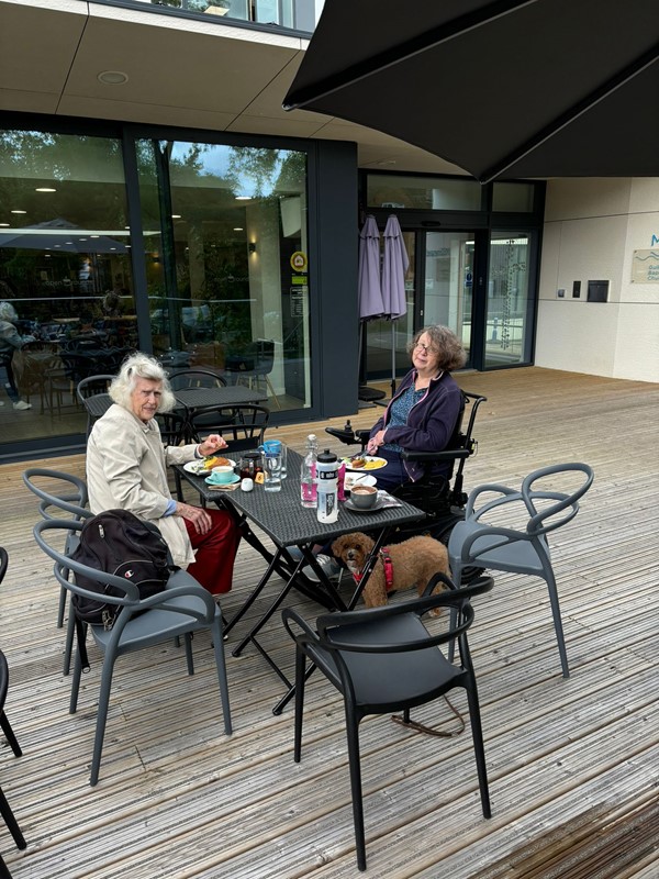 Image of two people and a dog sat outside