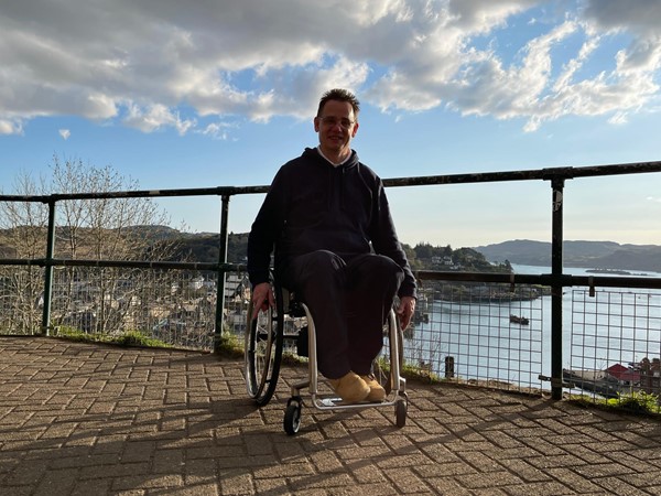 Image of Paul facing the camera with scenery behind him.