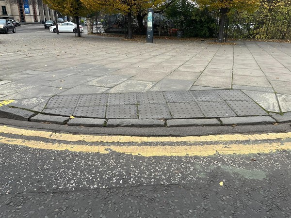 A slightly raised, cobbled and dipped pavement.