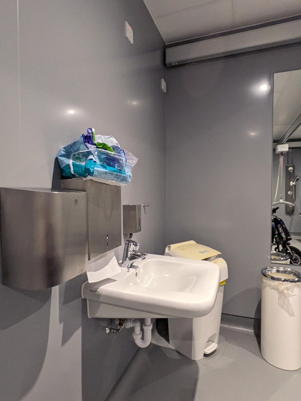 Image of the changing places toilet, showing the sink hand dryer and sanitary bins