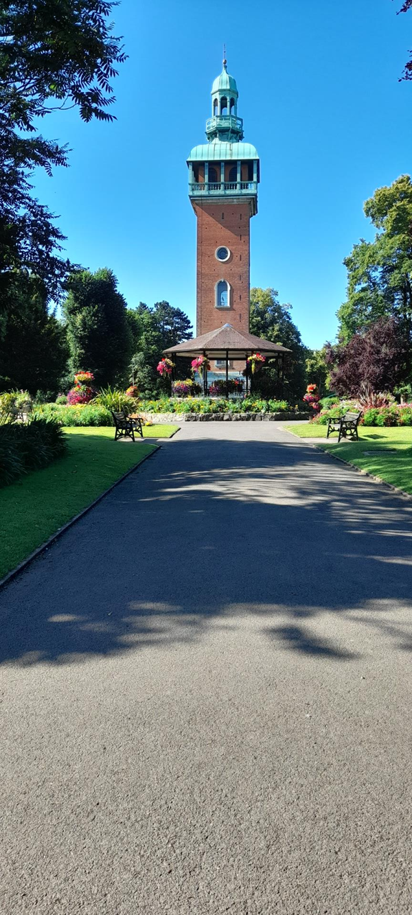 Loughborough Carillion and bandstand in Queens Park. The Carillion is a peel of 47 bells played from a set of levers set out like a piano keyboard. Recitals regularly on Thursday and Sunday at 1:00 PM. The Carillion Tower opened in 1922 and was constructed to remember those who died during World War I. Some of my relatives names appear on that tower. The area around the tower is wheelchair accessible from three sides but there are steps on the 4th.