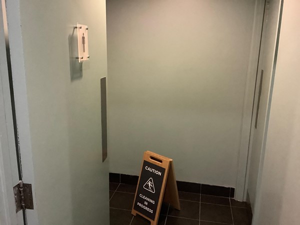 Men's toilet with cleaning in progress sign