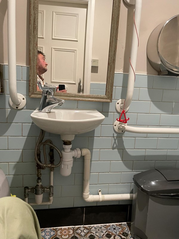 Image of a sink with a red cord tied up around a grabrail