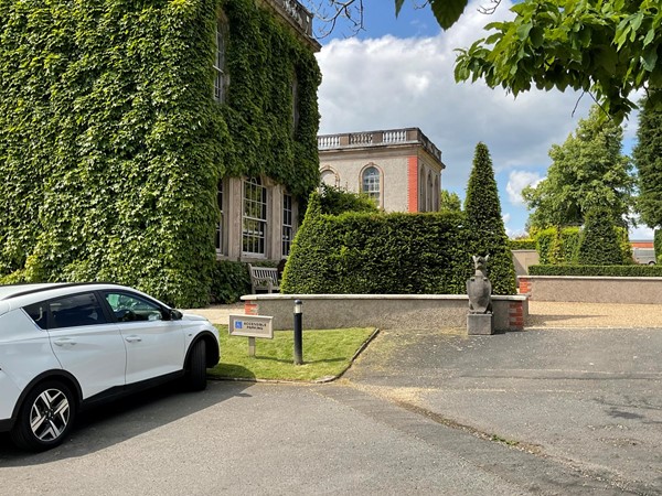 Image of a white car parked in front of a building