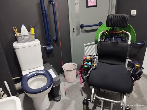 Chunky electric wheelchair showing how much space is available in the accessible loo