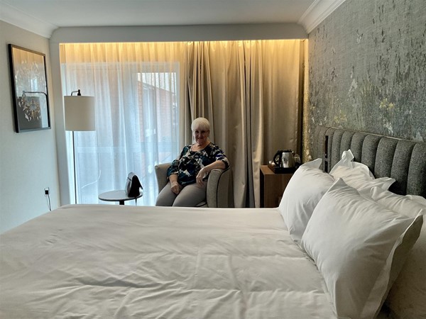 Image of a person sitting in a chair in a hotel room